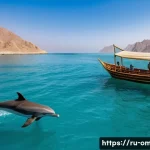 오만 돌고래 관찰 투어 - A serene early morning sea scene off the coast of Oman with calm turquoise waters and gentle sunligh...